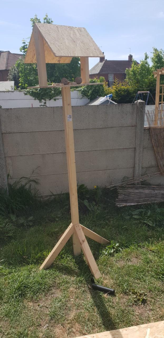 Two children made a bird table with their dad.